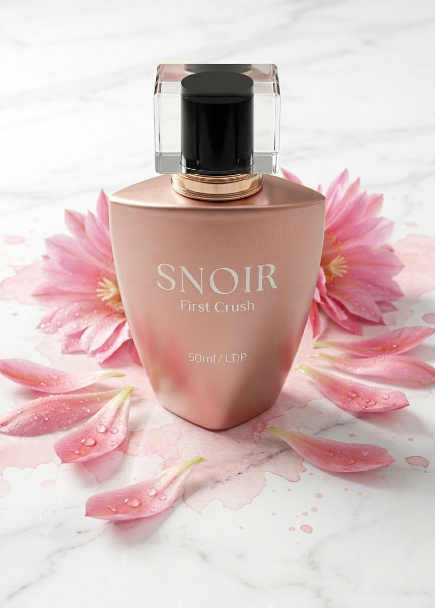 Perfume bottle labeled 'Snoir First Crush' with pink flowers on a light background